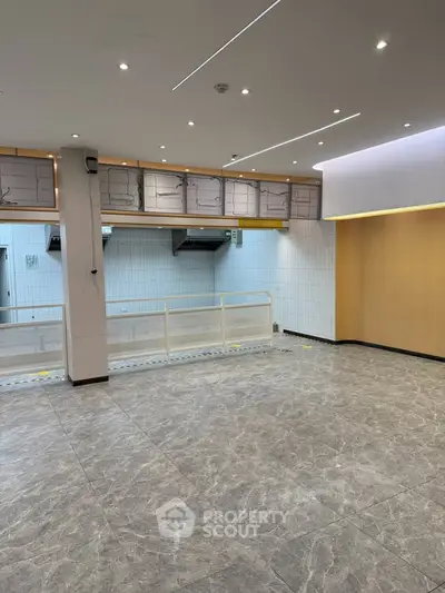 Spacious commercial space with modern lighting and tiled flooring, ideal for retail or office use.