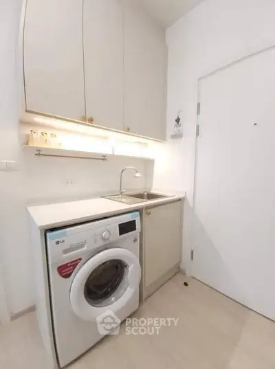 Modern compact kitchen with washing machine and sleek cabinetry