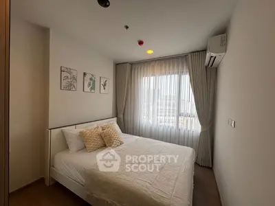 Cozy bedroom with elegant decor and large window offering natural light