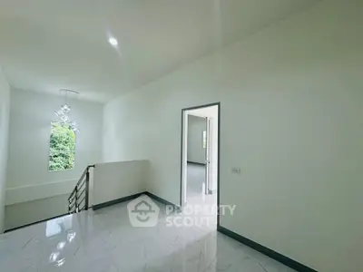 Spacious hallway with modern lighting and large window view