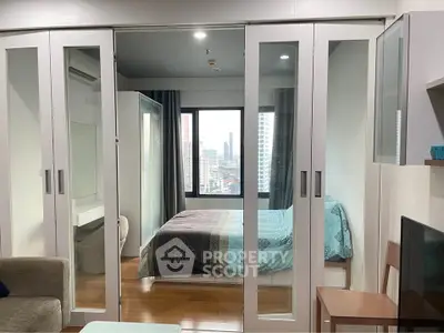 Modern bedroom with mirrored sliding doors and city view
