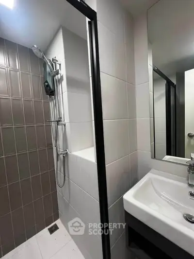 Modern bathroom with sleek shower and stylish sink in contemporary apartment.