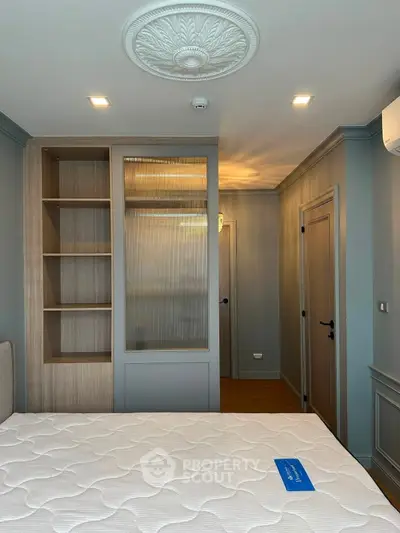 Elegant bedroom with modern design, featuring built-in shelves and stylish ceiling decor.