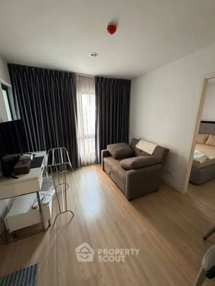 Cozy living room with modern decor and natural light, featuring a comfortable sofa and stylish flooring.