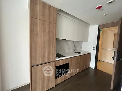 Modern kitchen with sleek wooden cabinetry and built-in appliances in a stylish apartment.