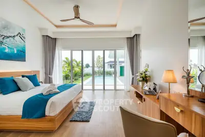 Luxurious bedroom with pool view, modern decor, and natural light.