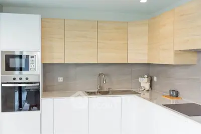 Modern kitchen with sleek cabinetry and built-in appliances, featuring a minimalist design and ample counter space.