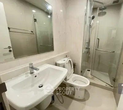Modern bathroom with glass shower and sleek fixtures in a contemporary apartment.