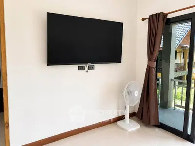 Modern living room with wall-mounted TV and sliding glass door to balcony