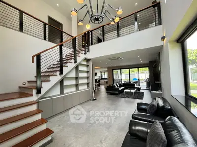 Luxurious modern living room with high ceilings, stylish staircase, and elegant furnishings.