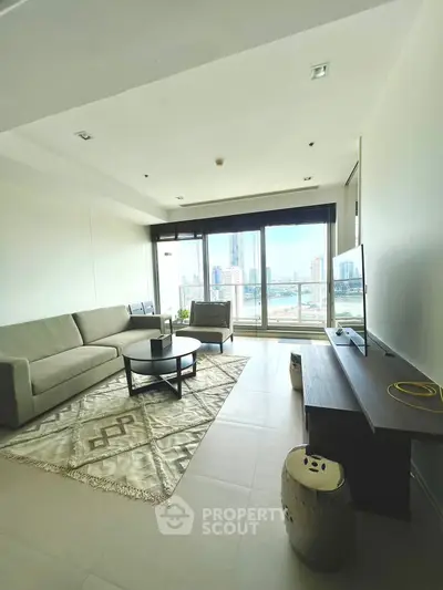 Spacious living room with modern decor and stunning city view through large windows.