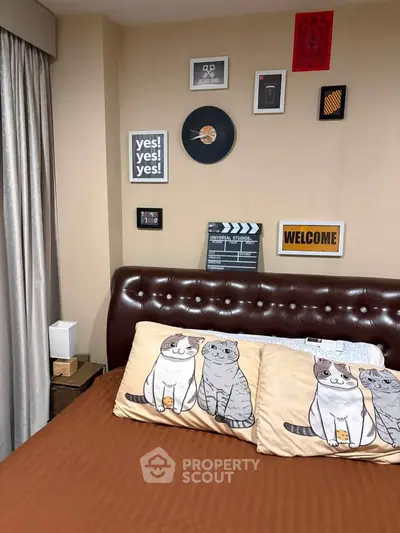 Cozy bedroom with stylish decor and cat-themed pillows, perfect for relaxation and comfort.