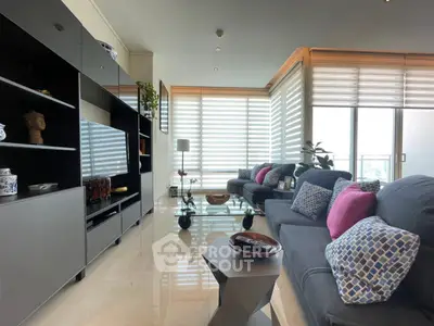 Spacious modern living room with stylish decor and large windows offering natural light.