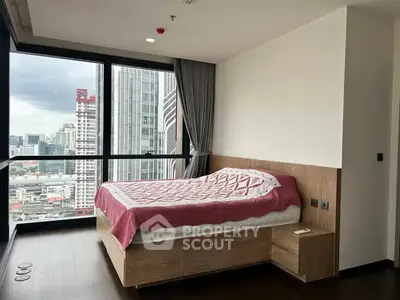 Modern bedroom with panoramic city view and stylish decor in high-rise apartment.