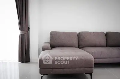 Modern living room with stylish gray sofa and elegant curtains