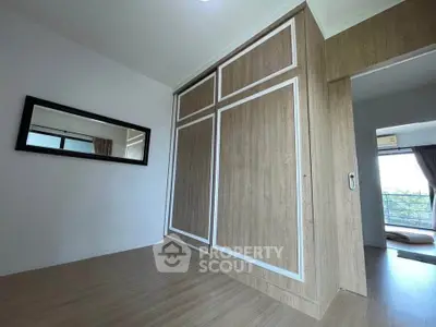 Spacious bedroom with wooden flooring and large mirrored wardrobe