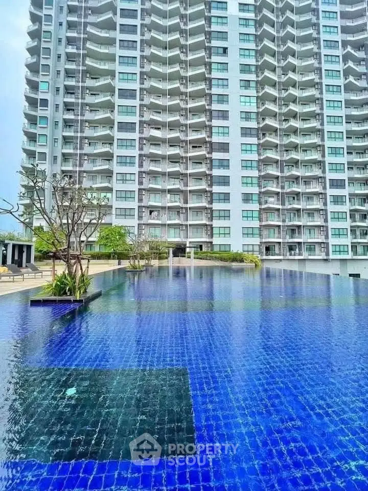 Luxurious high-rise building with stunning poolside view and modern architecture.