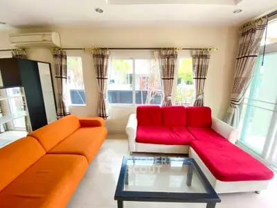 Bright and spacious living room with colorful sofas and large windows