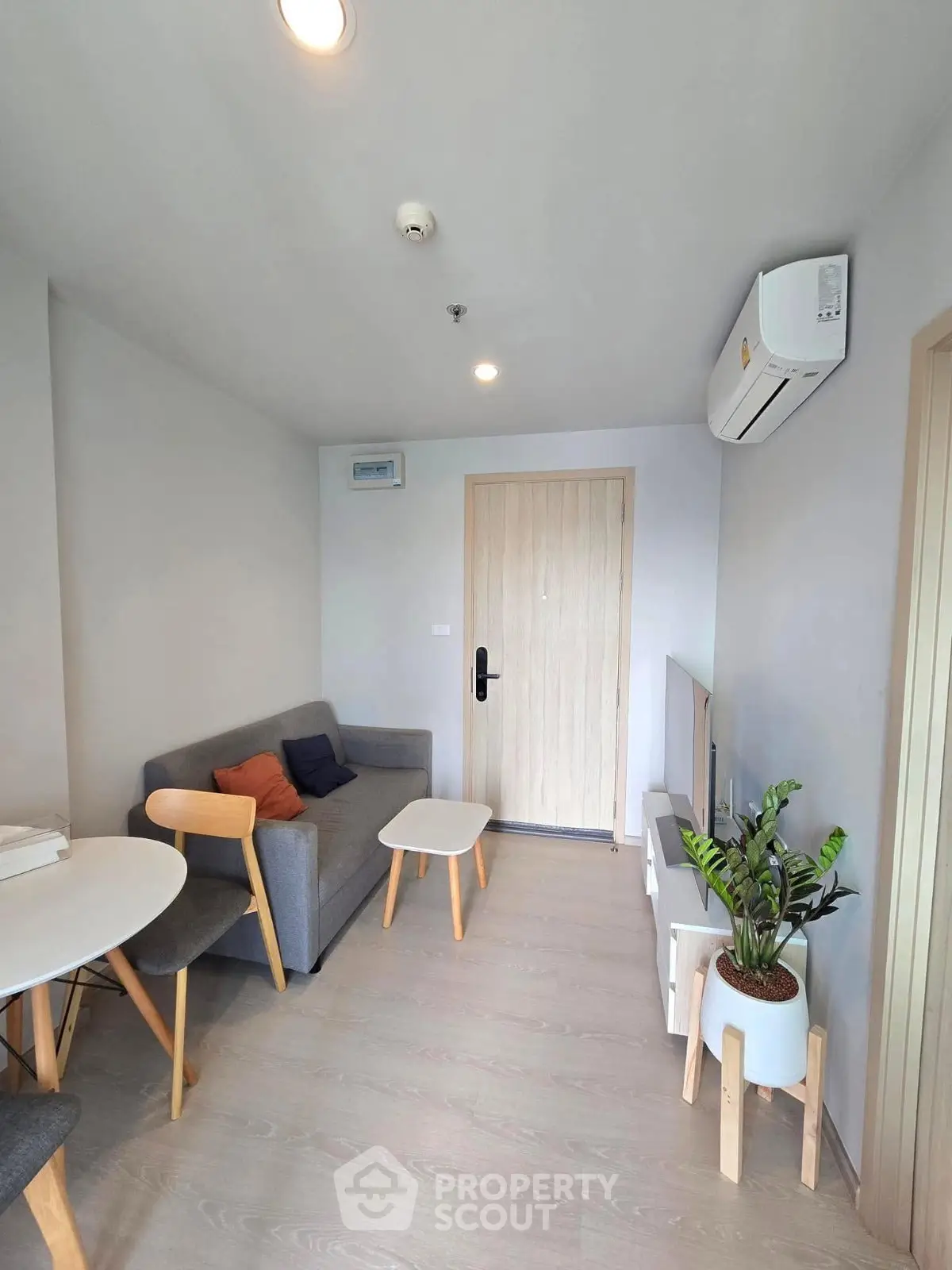 Modern living room with minimalist furniture and air conditioning in a cozy apartment.