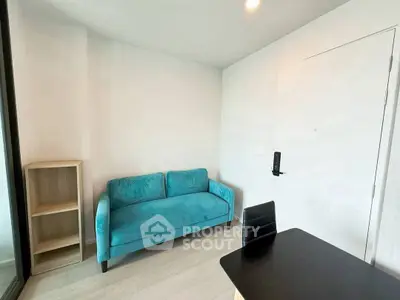Modern minimalist room with teal sofa and sleek black table, perfect for a cozy living space.