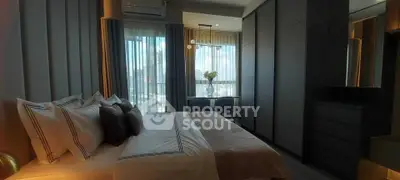 Modern bedroom with city view, stylish decor, and ample natural light.