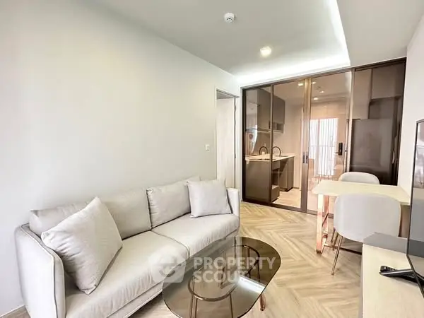 Modern living room with sleek glass table and cozy sofa in stylish apartment.