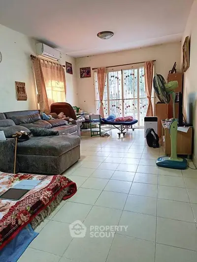 Spacious living room with cozy seating and natural light, perfect for family gatherings.