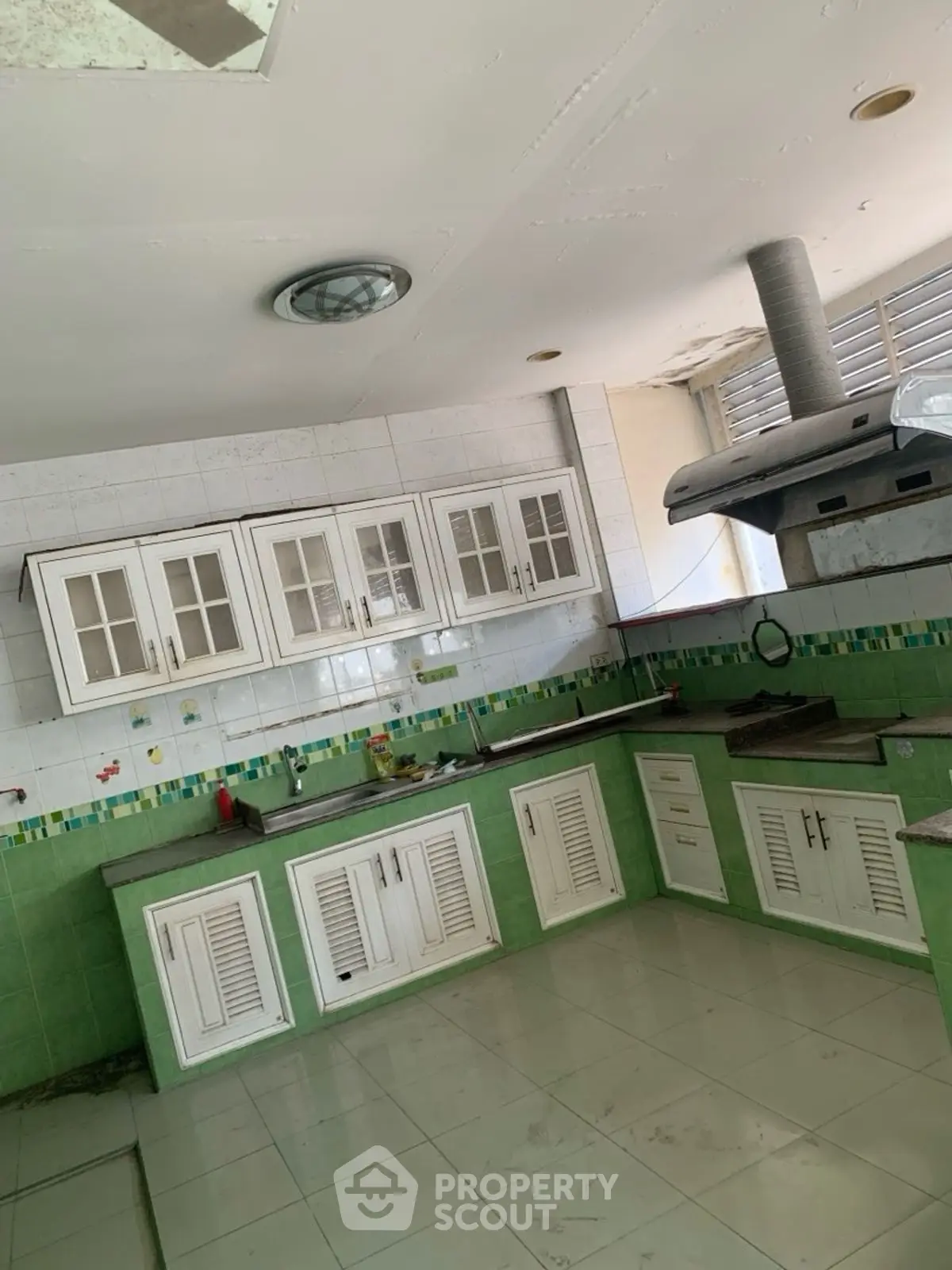 Spacious kitchen with green tile accents and ample cabinet storage
