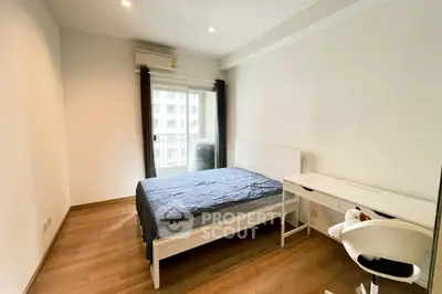 Modern bedroom with wooden flooring and balcony access in urban apartment