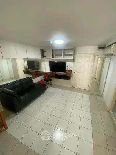 Spacious living room with modern decor and wall-mounted TV in a cozy apartment.