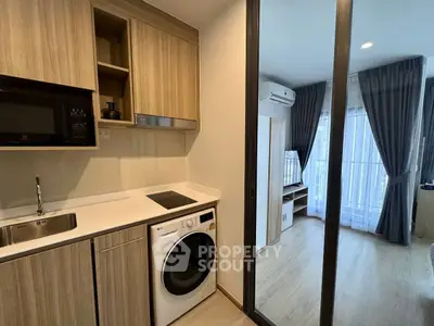 Modern compact kitchen with washing machine and open layout to bedroom