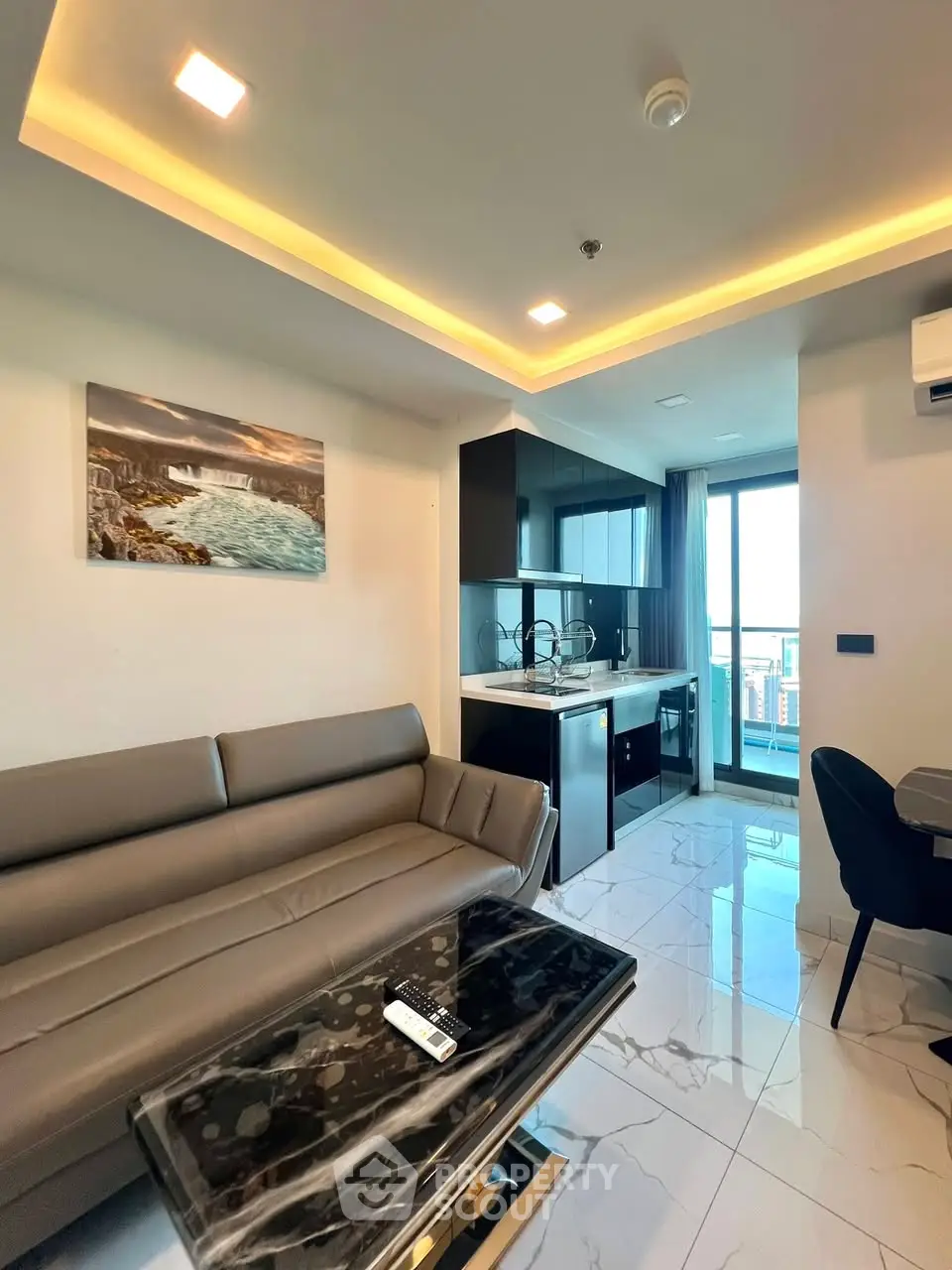 Modern living room with sleek kitchen and city view balcony