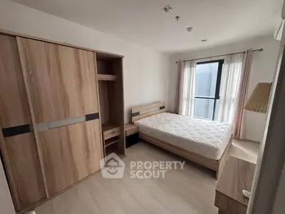 Modern bedroom with wooden furniture and large window in a stylish apartment.