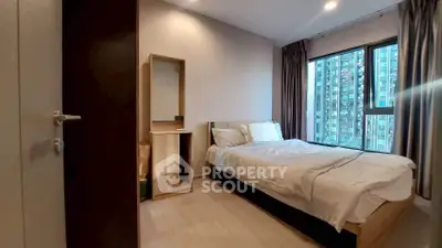 Modern bedroom with large window and city view in high-rise apartment
