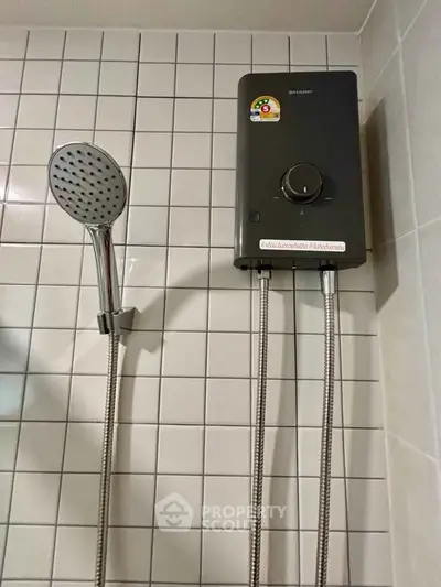 Modern bathroom with sleek showerhead and efficient water heater on tiled wall.