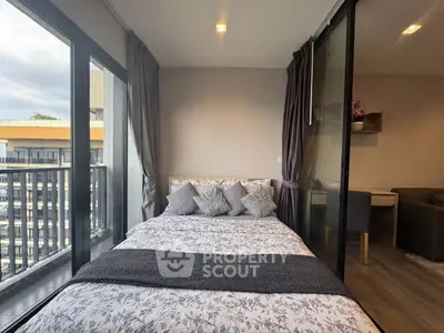 Modern bedroom with balcony view in urban apartment, featuring stylish decor and natural light.