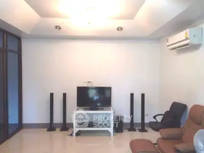 Spacious living room with modern entertainment setup and comfortable seating.