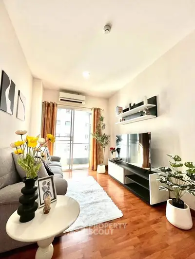 Bright and modern living room with stylish decor and large TV, perfect for relaxation.