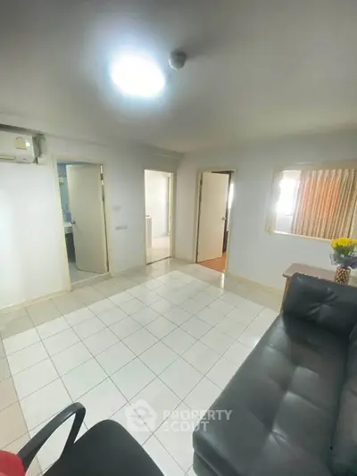 Spacious living room with modern sofa and bright lighting, ideal for comfortable living.