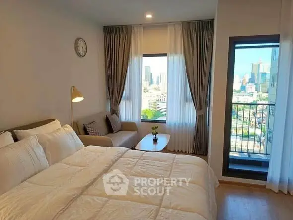 Modern bedroom with city view and cozy seating area