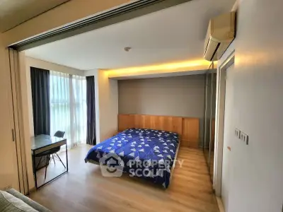 Spacious bedroom with modern decor and natural light in a stylish apartment.