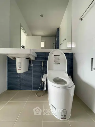 Modern bathroom with sleek toilet and blue tile accent wall