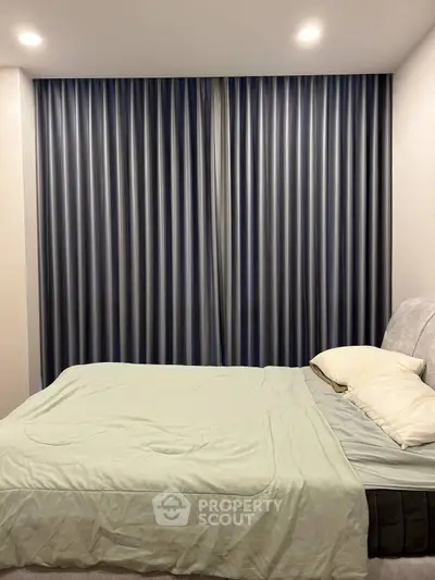 Cozy bedroom with elegant curtains and soft lighting, perfect for relaxation.