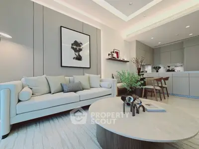 Modern living room with elegant decor and open kitchen layout, featuring stylish furniture and contemporary design.