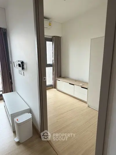 Modern minimalist room with wooden flooring and natural light, perfect for cozy living.