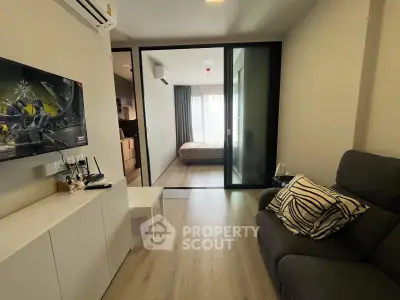 Modern apartment interior with cozy living room and bedroom view, featuring sleek design and comfortable furnishings.