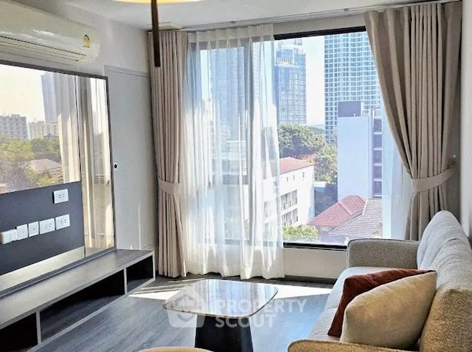 Modern living room with large window offering stunning city view, cozy sofa, and elegant decor.