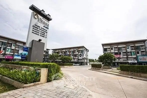 Modern commercial complex with multiple storefronts and ample parking space.