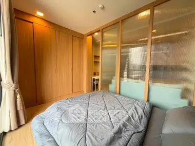 Modern bedroom with wooden accents and cozy bedding in a stylish apartment.