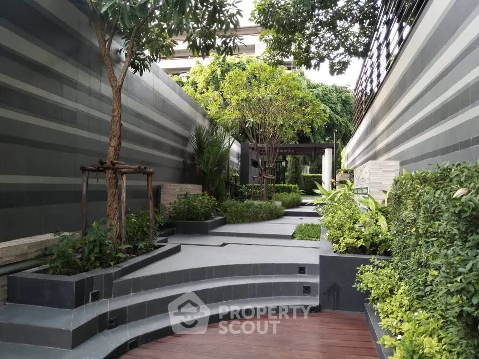 Modern landscaped garden with sleek design and lush greenery in a residential complex.